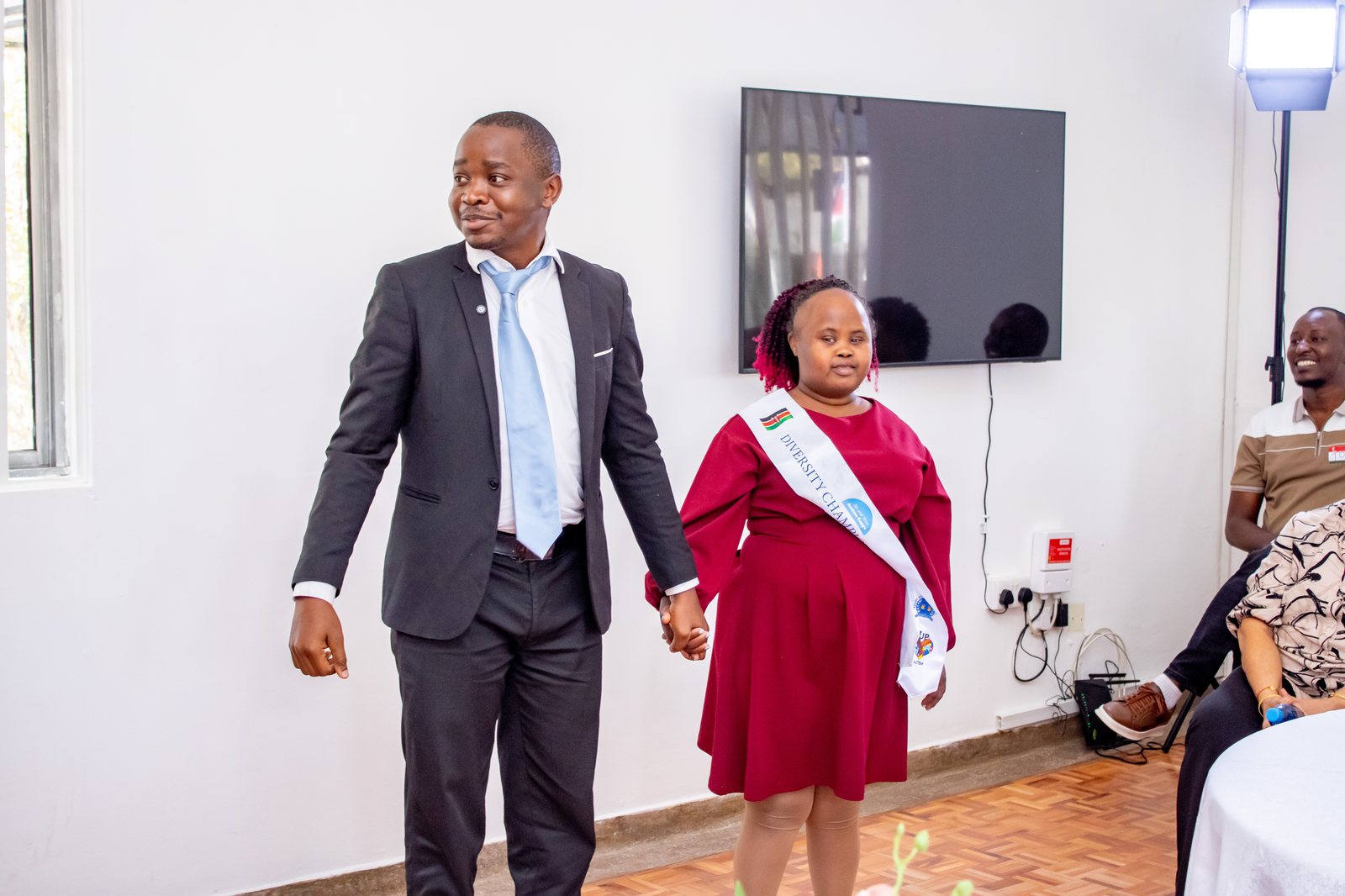 A Thrive Pamoja diversity champion walking hand in hand with a staff member